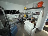 a kitchen with a lot of pots and pans on the shelves