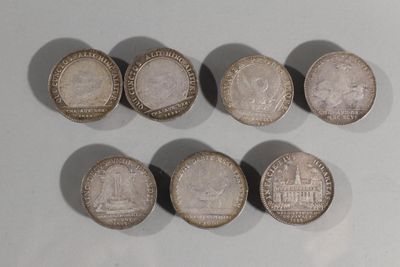 six pièces de monnaie britanniques différentes posées sur une surface blanche