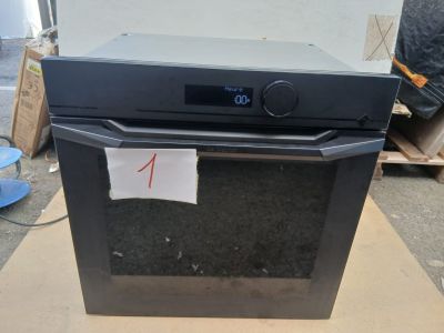un four noir posé sur une boîte en carton
