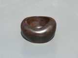 a wooden bowl sitting on a table with a white surface
