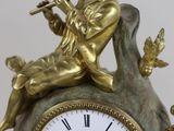 a gold clock with a boy sitting on top of it