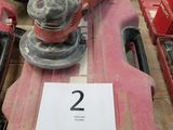 une photo d'une boîte à outils rouge sur laquelle est posée une ponceuse