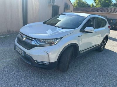 une Honda CR-V blanche garée devant une maison