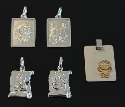 quatre pendentifs en argent et en or représentant un homme et une femme