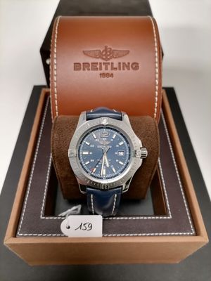 the watch is in a box with a brown leather strap
