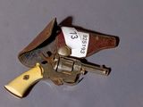 un petit revolver dans un étui en cuir posé sur la table