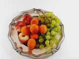 a plate of fruit on a table with a white background