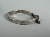 silver bracelet with black beads and a chain on a white surface