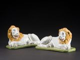 pair of white and orange lion figurines on green bases