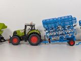 three toy tractors and a tractor on a white surface