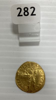 gros plan d'une pièce d'or sur une surface blanche