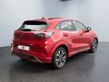 the rear end of a red car in a showroom