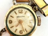 a gold wrist watch with a chain attached to it
