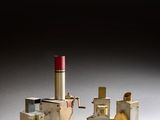 une petite maquette d'usine d'où sort un tuyau rouge sur le côté