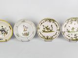 quatre assiettes à motifs différents posées sur une surface blanche