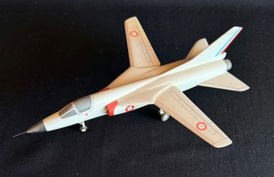 une maquette d'avion de chasse posée sur une surface noire