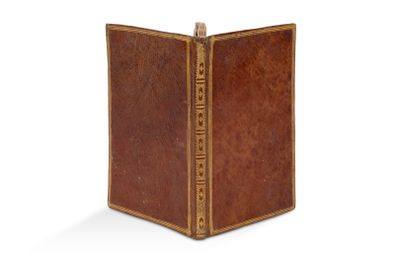 un vieux livre à la couverture brune et à la bordure dorée