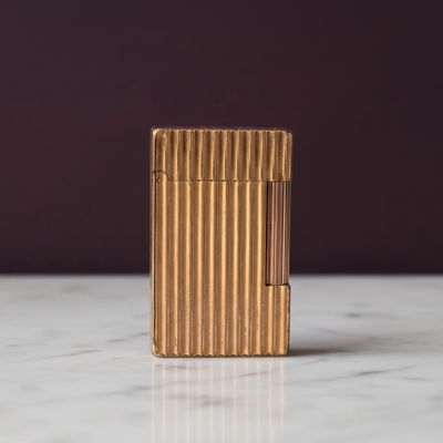 un briquet en or posé sur un plan de travail en marbre