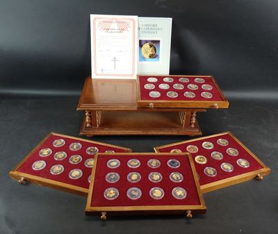 trois plateaux en bois contenant des pièces d'or et une carte, posés sur une table