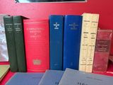 several books on a table with a red wall in the background