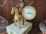 a statue of a man riding a horse with a clock on it