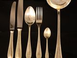 a lot of silver spoons and forks on a table
