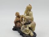 chinese carved ivory figurine of a man and a woman sitting on a rock
