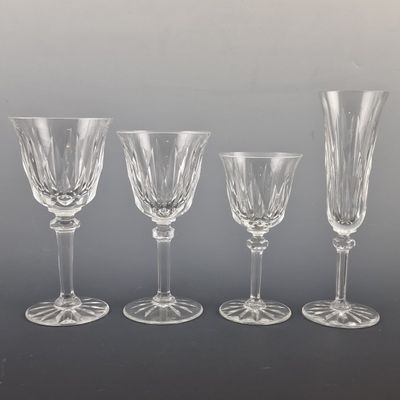 four clear wine glasses sitting on top of a table