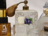 many different bottles of perfume sitting on a table