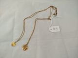 a close up of two gold necklaces on a white surface