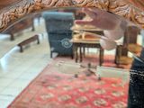a person standing in front of a mirror that is reflecting a living room