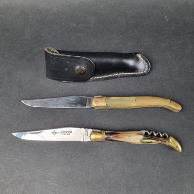 three different types of knives on a table with a leather sheath