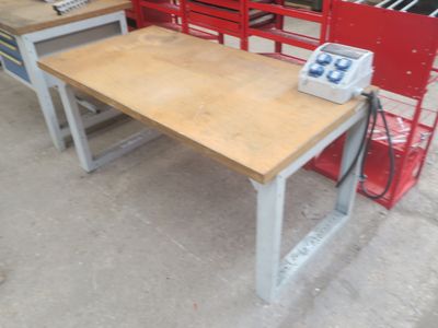 une table en bois sur laquelle se trouve un téléphone, dans un garage