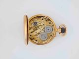 a gold pocket watch on a white surface