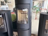 three black wood burning stoves sitting on pallets in a warehouse