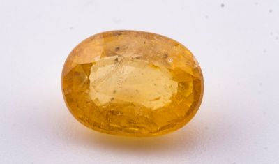 gros plan d'une pierre de saphir jaune sur une surface blanche
