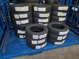 several tires stacked on top of a blue cart in a warehouse