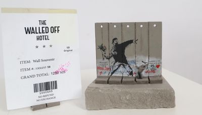 a statue of a man holding a gun next to a hotel sign