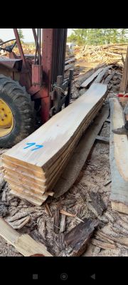 un chariot élévateur garé à côté d'un tas de bois