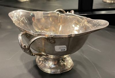 a silver bowl on a table with a mirror in the background