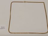 un collier en or avec une chaîne sur un fond blanc