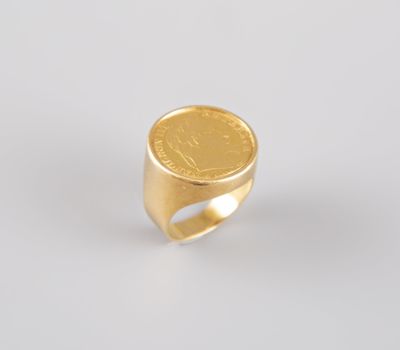 une bague en forme de pièce d'or sur un fond blanc