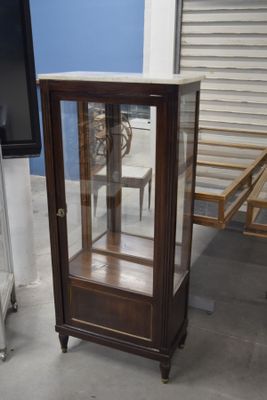 une vitrine en verre dans le coin d'une pièce