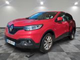 une voiture rouge est garée sur le sol en damier d'un garage