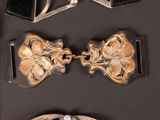 a pair of scissors sitting on a table next to a pair of brooches