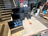 two laptops sitting on a table in a warehouse