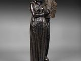 une statue en bronze représentant une femme tenant une harpe