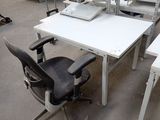 un bureau blanc avec deux chaises et un ordinateur posé dessus