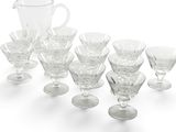 a lot of wine glasses and a pitcher on a table