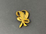 une image représentant une broche en or ornée d'une feuille